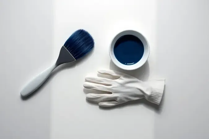 Composição minimalista com ferramentas para aplicação caseira de tinta preto azulado.