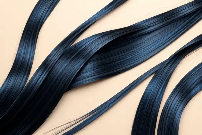 Mechas de cabelo preto azulado com reflexos sutis em tom azul sob iluminação suave em renderização 3D conceitual.
