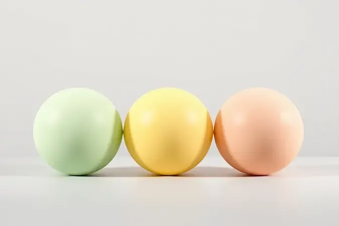 Render 3D de esferas verde, amarela e salmão representando corretivos coloridos para neutralização de tons.